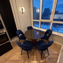 Круглый обеденный стол с черной глянцевой столешницей и синими стульями &mdash; стильное и функци...