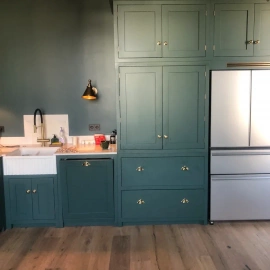 Элегантная кухня с зелёными шкафами и серебристым холодильником &ndash; стильное и функциональное...