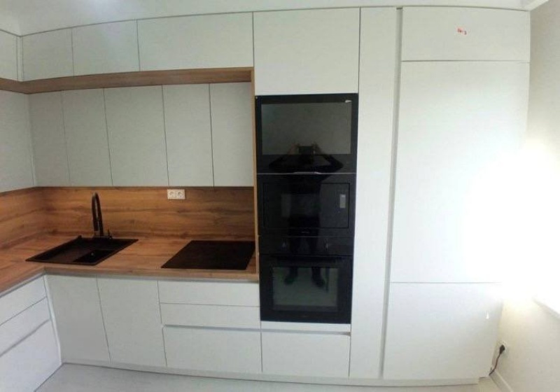 Белая акриловая кухня без ручек — профиль Gola, чёрные акценты и тёплое дерево в г. Москва