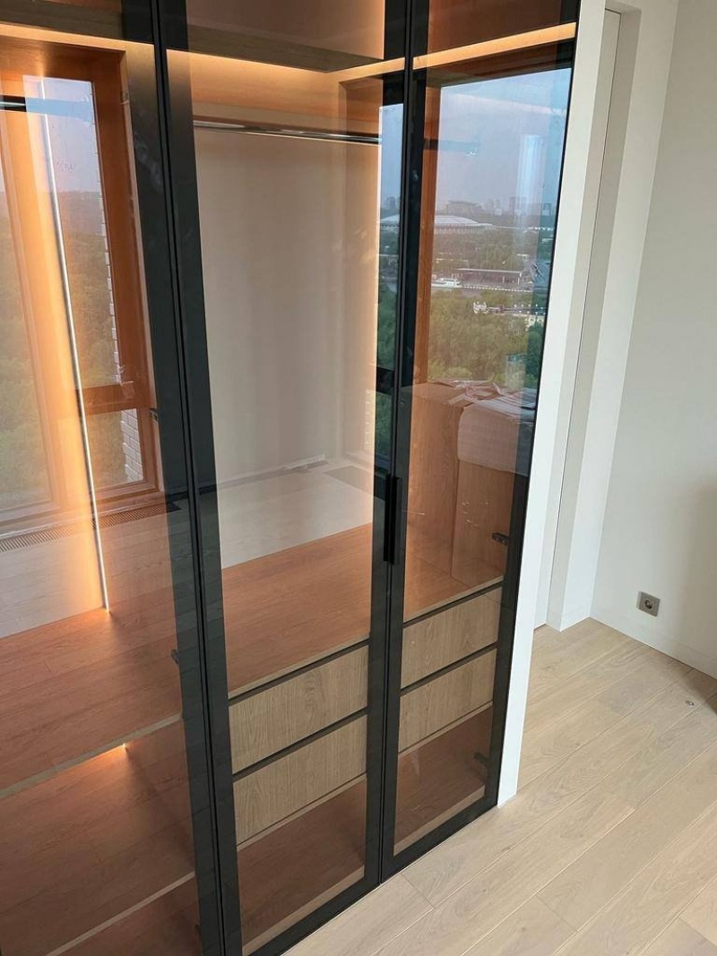 Современная гардеробная с LED-подсветкой и стеклянными фасадами на заказ