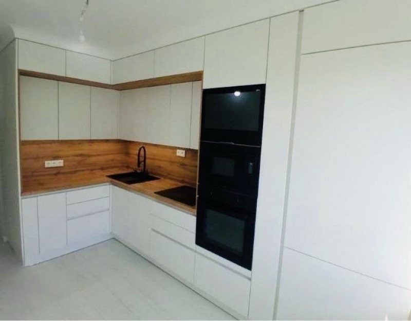 Белая акриловая кухня без ручек — профиль Gola, чёрные акценты и тёплое дерево в г. Москва